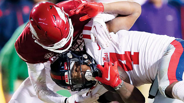 Ole Miss Rebels running back Quinshon Judkins is tackled by Arkansas Razorbacks defensive back Hudson Clark during the fourth quarter at Razorback Stadium. Arkansas won 42-27 in a game that wasn't nearly as close as the score would suggest.